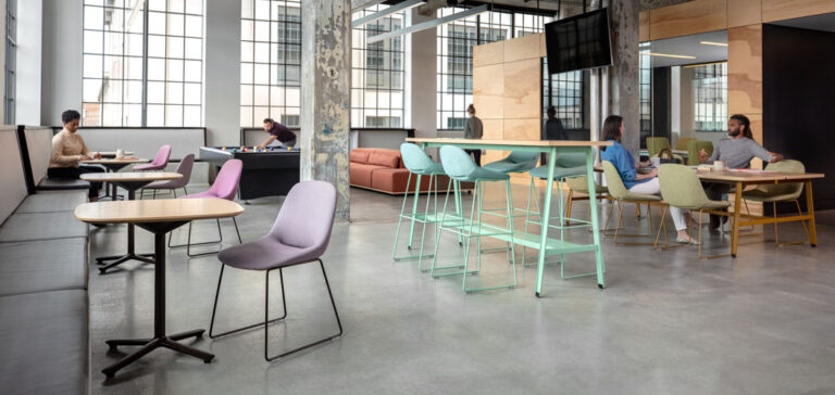 A cafe setting with many different chair and banquette styles with people sitting and happily chatting