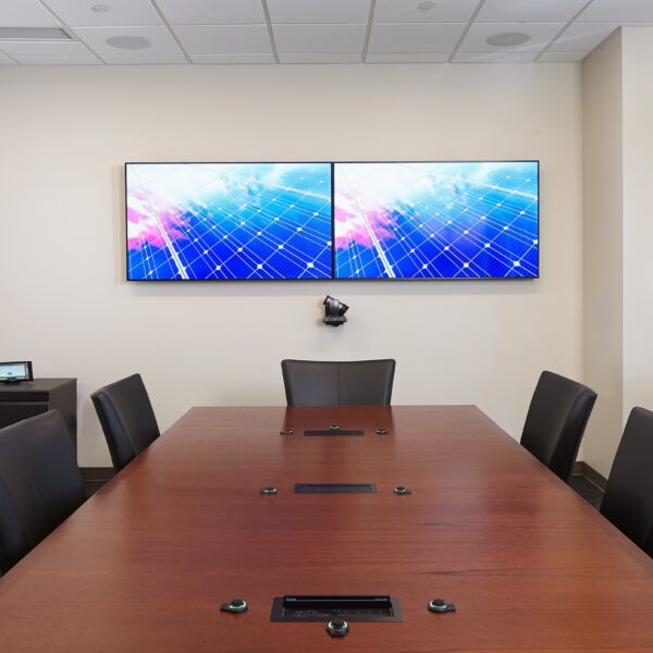 conference room with wood table, 2 televisions at the front of the room, and a whiteboard