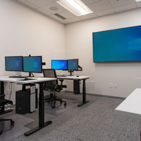 Training Room showing multiple desks with double monitors and a large tv display at the front of the rom