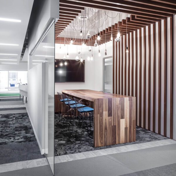 a large wood collaboration hub table with a tv for meetings