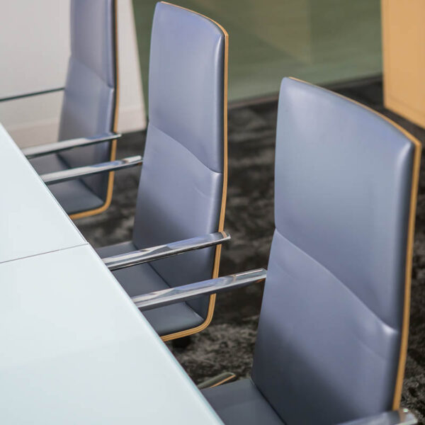 executive conference chairs with leather and metal arms shown at a glass top table