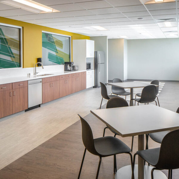 breakroom with tables, chairs, stools at a built in counter, and millwork