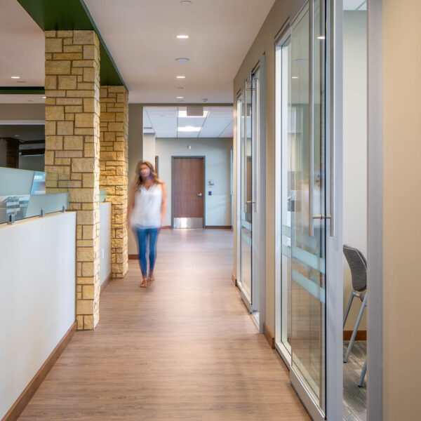 Person walking between desk panels and glass wall architectural solutions
