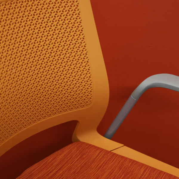 close up of chair with upholstered seat and flex back for comfort