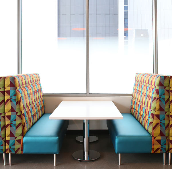 Banquettes in a breakroom with colorful upholstery to match client branding