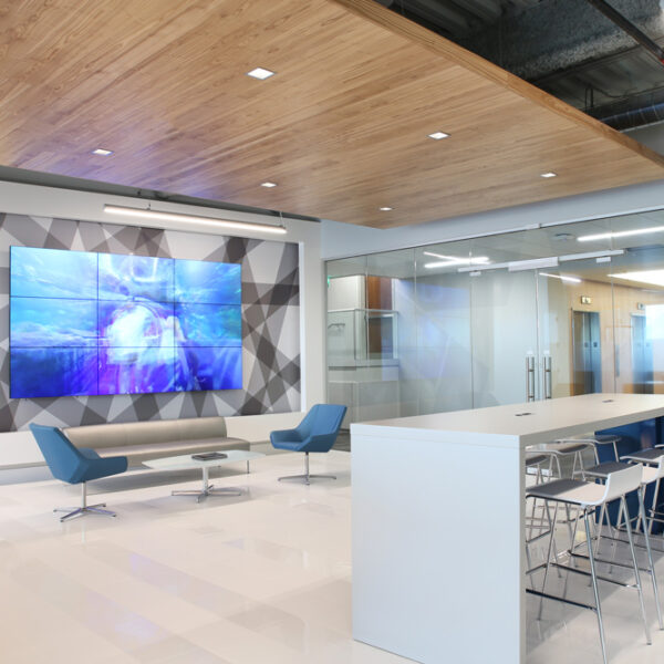 Lobby area with large video wall, soft seating, and sleek hub table