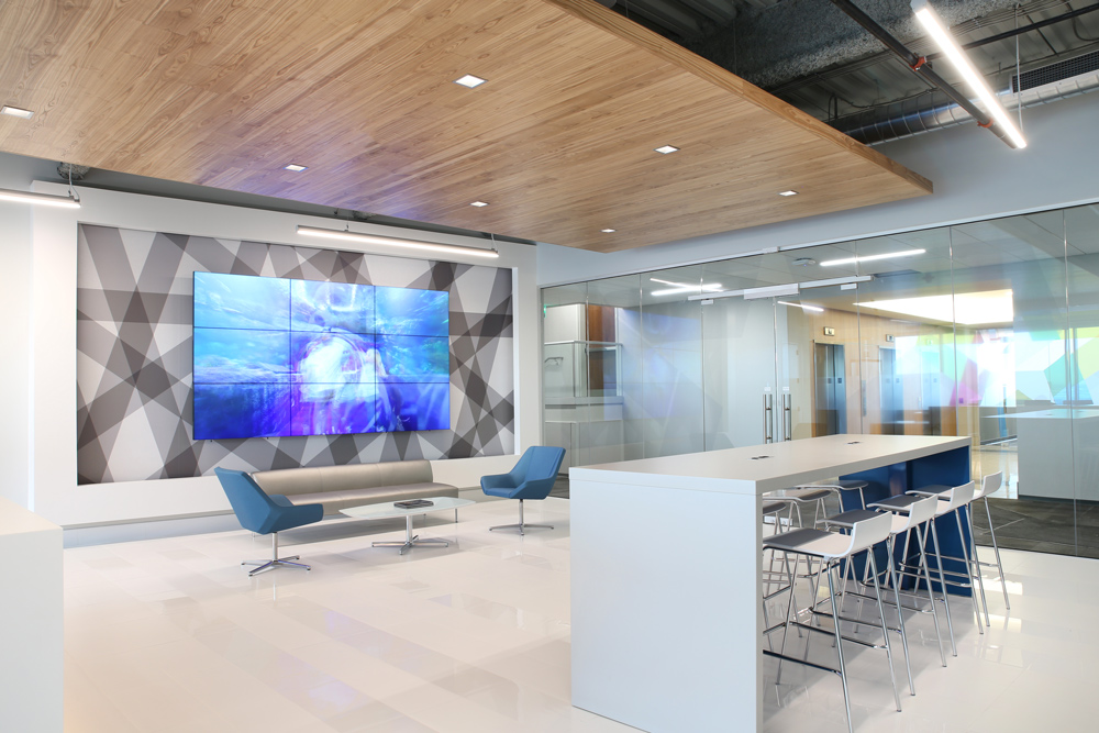 Lobby area with large video wall, soft seating, and sleek hub table
