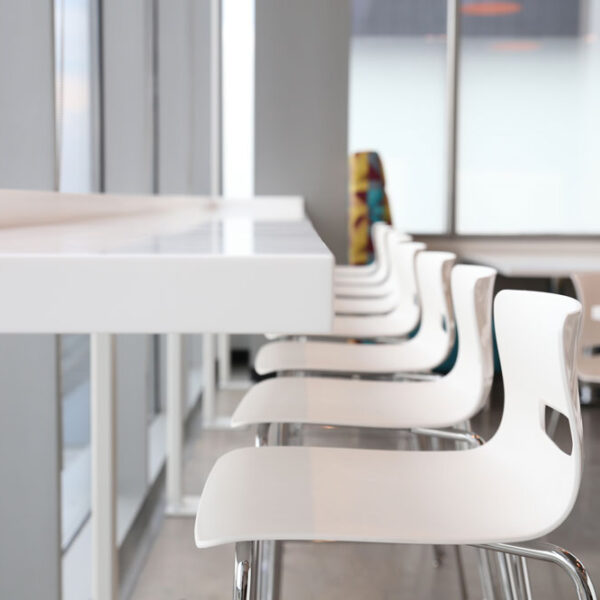 A line of stools at a window mounted worksurface