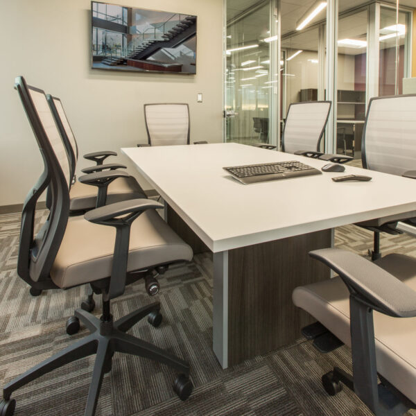 conference room with wood and laminate meeting table, ergonomic chairs, and tv display